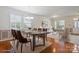Open-concept dining room with hardwood floors, a chandelier, a sleek table, and views into the living room at 8915 Merrie Rose Ave, Charlotte, NC 28213