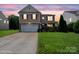 Beautiful two-story home with manicured lawn at sunset, stone accents, and an attached two-car garage at 8915 Merrie Rose Ave, Charlotte, NC 28213