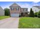 Charming two-story home with a manicured lawn, stone accents, and an attached two-car garage at 8915 Merrie Rose Ave, Charlotte, NC 28213
