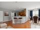 Eat-in kitchen features hardwood floors, breakfast bar, stainless appliances, and adjacent dining area at 8915 Merrie Rose Ave, Charlotte, NC 28213