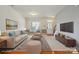 Light-filled living room with hardwood floors, stylish decor, large window and ample seating, virtually staged at 8915 Merrie Rose Ave, Charlotte, NC 28213