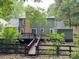 Backyard featuring a large home, a brick chimney, a wooden deck, and stairs at 9305 Harps Mill Ct, Charlotte, NC 28270
