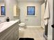 Bathroom with a gray vanity, decorative window, neutral color palette, and tiled flooring at 9305 Harps Mill Ct, Charlotte, NC 28270