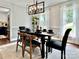 Elegant dining room with a modern chandelier, a table set for dinner, and ample natural light at 9305 Harps Mill Ct, Charlotte, NC 28270