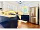 Modern kitchen with stainless steel appliances, white cabinets, and contrasting dark blue base cabinets at 9305 Harps Mill Ct, Charlotte, NC 28270