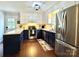 Bright kitchen with white and blue cabinets, stainless steel appliances, and hardwood floors at 9305 Harps Mill Ct, Charlotte, NC 28270