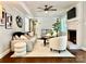 Bright living room with a cozy fireplace, ceiling fan, modern furniture, and natural light from a window at 9305 Harps Mill Ct, Charlotte, NC 28270