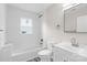 Bright bathroom featuring all white fixtures and finishes and a window above the bathtub at 1017 W Fisher St, Salisbury, NC 28144