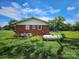 Exterior home view displaying a large propane tank nestled in the backyard with mature trees at 1050 Old Peachland Rd, Marshville, NC 28103