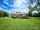 Charming single-story brick home featuring a well-manicured lawn and inviting front porch at 1050 Old Peachland Rd, Marshville, NC 28103