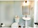 Half bathroom featuring a pedestal sink and toilet with a framed mirror and light fixture at 11123 Waxberry Dr, Charlotte, NC 29277