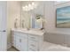 Well-lit bathroom with white cabinets, quartz countertop, large mirror, and elegant decor at 11313 Limehurst Pl, Charlotte, NC 28278