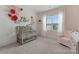 Adorable Bedroom with floral wall decorations, a light wood crib, and a soft pink chair by a window at 11313 Limehurst Pl, Charlotte, NC 28278