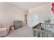 Bedroom with crib and changing table; light pink walls create a peaceful and inviting atmosphere for the baby at 11313 Limehurst Pl, Charlotte, NC 28278