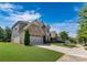 Attractive home with a manicured lawn, paved driveway, and a mix of brick and stone exterior at 11313 Limehurst Pl, Charlotte, NC 28278