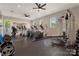 Spacious gym featuring multiple cardio machines, weights, ceiling fans and a mirrored wall at 11313 Limehurst Pl, Charlotte, NC 28278