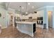 Bright, open kitchen featuring a large center island, modern appliances, and stylish pendant lighting at 11313 Limehurst Pl, Charlotte, NC 28278