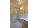 Elegant marble bathroom with glass enclosed shower and ornate vanity with sink at 1137 Queens W Rd, Charlotte, NC 28207