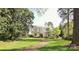 Charming two-story home with a brick walkway, lush green lawn, and mature trees offering shade at 1137 Queens W Rd, Charlotte, NC 28207