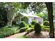Charming home with manicured hedges, beautiful landscaping, and a brick pathway at 1137 Queens W Rd, Charlotte, NC 28207