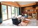 Stylish living room features wood walls, large windows, comfortable chairs, and entertainment setup at 1137 Queens W Rd, Charlotte, NC 28207