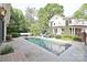 Backyard pool with stone patio, lounge chairs, and lush landscaping offers the perfect spot for relaxation at 1137 Queens W Rd, Charlotte, NC 28207