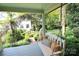 Inviting front porch with a swing, pillows, and a beautiful view of the yard at 1137 Queens W Rd, Charlotte, NC 28207