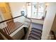 Staircase with light walls and dark wood trim leading to a seating nook with windows at 1137 Queens W Rd, Charlotte, NC 28207