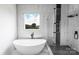 This bathroom features an oval tub, black accents, a glass shower, and marble-look tile surround at 115 Augusta Ln, Shelby, NC 28150