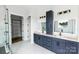 Bathroom featuring double sinks, blue cabinets, marble countertops, and a large frameless glass shower at 115 Augusta Ln, Shelby, NC 28150
