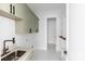 Well-equipped laundry room with cabinetry, shelving, a sink, and marble floors at 115 Augusta Ln, Shelby, NC 28150