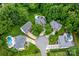 Aerial view of several homes in a cul-de-sac surrounded by lush trees and manicured lawns at 12002 Cobham Ct, Huntersville, NC 28078