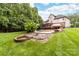 Expansive backyard with pool, fire pit, patio, lush lawn, and mature trees at 12002 Cobham Ct, Huntersville, NC 28078