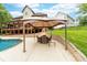 Enjoy outdoor dining in a covered area with the backyard pool nearby at 12002 Cobham Ct, Huntersville, NC 28078
