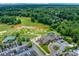 Aerial view of the clubhouse with pond, golf course, ample parking, and lush greenery at 12002 Cobham Ct, Huntersville, NC 28078