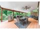 Covered deck boasts outdoor dining and seating areas, offering scenic backyard views at 12002 Cobham Ct, Huntersville, NC 28078