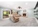 Cozy living room with plush seating, brick fireplace, and sliding door access to a covered patio at 12002 Cobham Ct, Huntersville, NC 28078