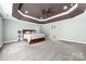 Spacious main bedroom with a ceiling fan, trey ceiling, and ensuite bathroom entrance at 12002 Cobham Ct, Huntersville, NC 28078