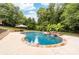 Backyard oasis with a beautiful pool featuring a rock waterfall and lush landscaping at 12002 Cobham Ct, Huntersville, NC 28078