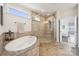 Bright bathroom with a luxurious soaking tub and a spacious glass-enclosed shower at 12410 Franklin Park Ln, Huntersville, NC 28078