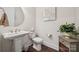Half bathroom featuring pedestal sink, decorative mirror, and wood floors at 12410 Franklin Park Ln, Huntersville, NC 28078
