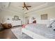 Comfortable main bedroom featuring a tray ceiling, a ceiling fan, and hardwood floors at 12410 Franklin Park Ln, Huntersville, NC 28078