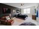 Stylish bedroom with brick accent wall, ceiling fan, large window, and comfortable seating area for relaxation at 15103 Cimarron Hills Ln, Charlotte, NC 28278