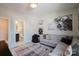 Inviting bonus room leading to an ensuite bathroom, featuring a comfortable couch, sports decor, and neutral tones at 15103 Cimarron Hills Ln, Charlotte, NC 28278