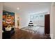 Spacious bonus room with hardwood floors, featuring an accent wall, decorative rug, and ample natural light at 15103 Cimarron Hills Ln, Charlotte, NC 28278