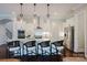 Bright kitchen with stainless steel appliances, a spacious island with bar stools, and modern lighting fixtures at 15103 Cimarron Hills Ln, Charlotte, NC 28278