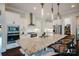 Gourmet kitchen features granite countertops, stainless steel appliances, a central island with seating, and modern cabinetry at 15103 Cimarron Hills Ln, Charlotte, NC 28278
