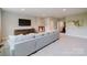 Bright living room with a large gray sofa, tv, and access to a bathroom at 15103 Cimarron Hills Ln, Charlotte, NC 28278