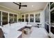Relaxing covered patio with comfortable seating, ceiling fan, and screened-in enclosure for outdoor enjoyment at 15103 Cimarron Hills Ln, Charlotte, NC 28278