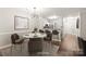 Elegant dining room with modern light fixture, marble table, and view of the kitchen at 16344 Redstone Mountain Ln, Charlotte, NC 28277